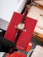 Wristwatch with brown leather strap and round white dial in red gift box
