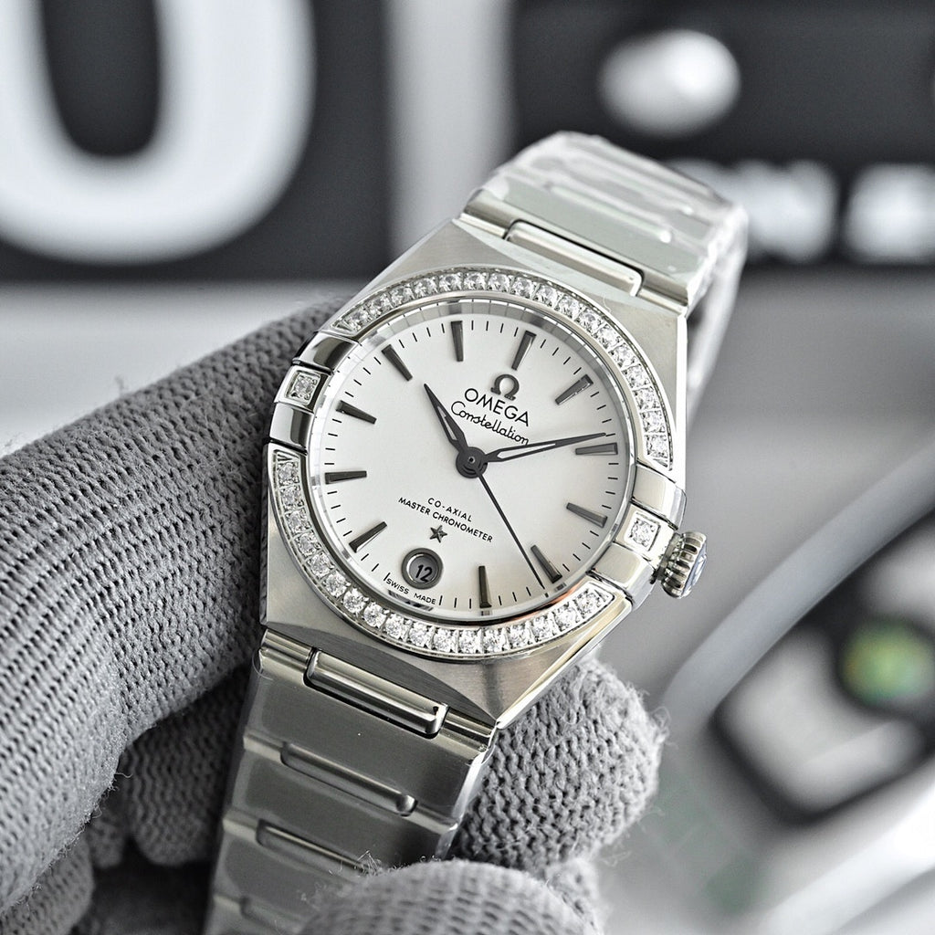Omega Constellation wristwatch with silver bracelet, white dial, and diamond bezel