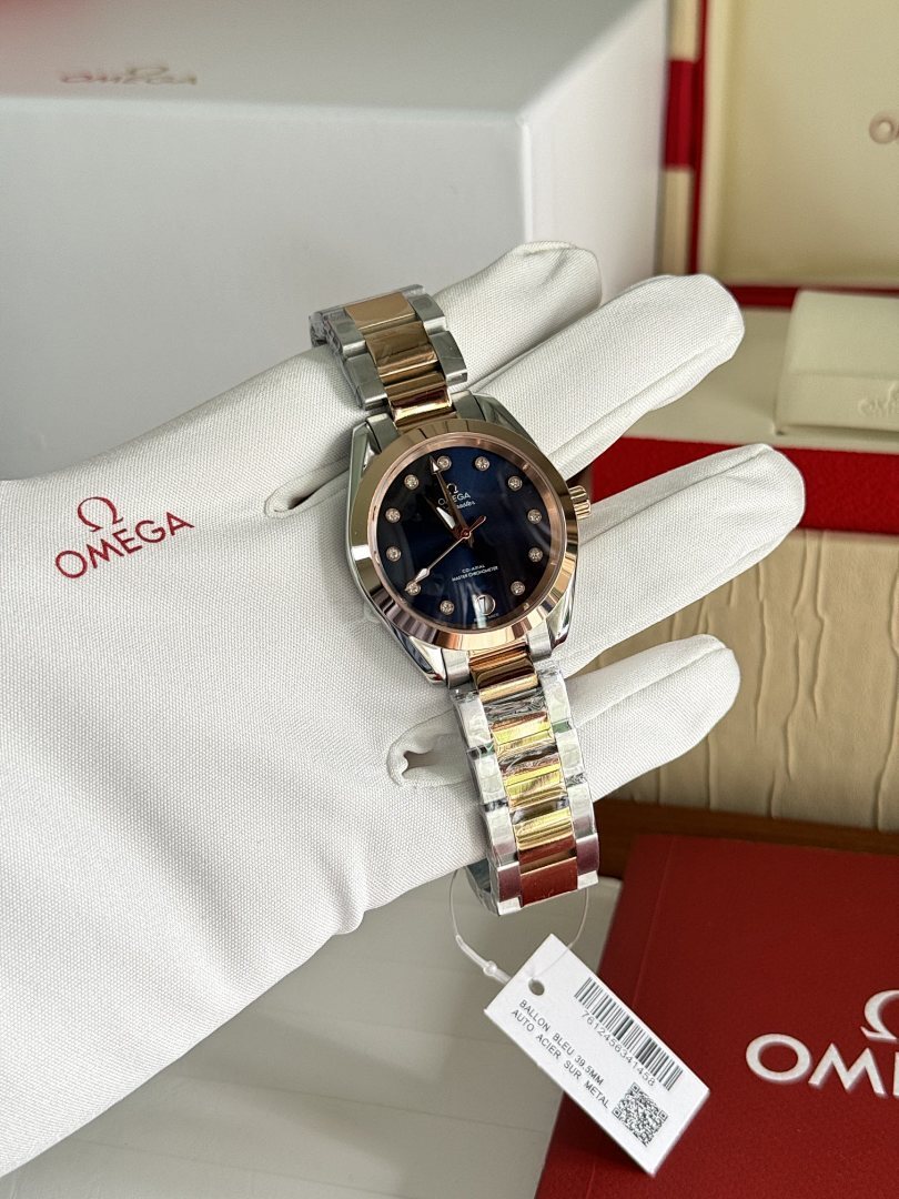 Two-tone metal wristwatch with dark blue dial and gold-tone bezel on white gloves