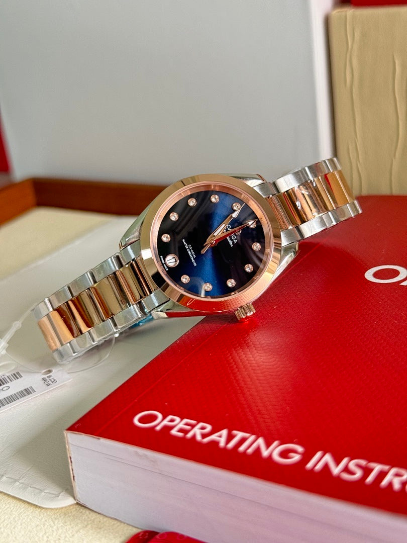 Two-tone wristwatch with dark blue dial on red box, closer angled view