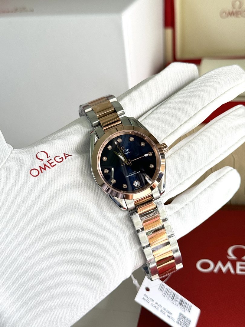Two-tone metal wristwatch with dark blue dial on white gloves