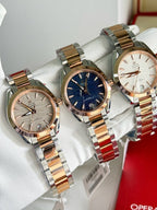 Set of three metal wristwatches with blue and silver dials on white pillows