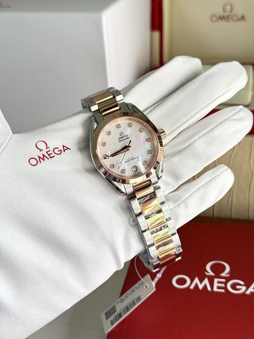 Omega wristwatch with two-tone metal bracelet and light dial on white glove