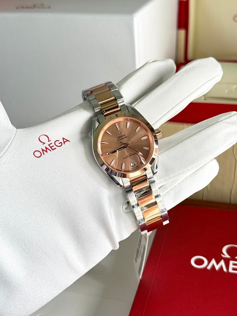 Omega wristwatch with two-tone metal bracelet and rose-gold dial on white glove