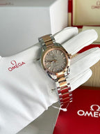 Omega wristwatch with two-tone metal bracelet and gray dial on white glove