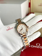 Omega wristwatch with two-tone metal bracelet and champagne dial on white glove