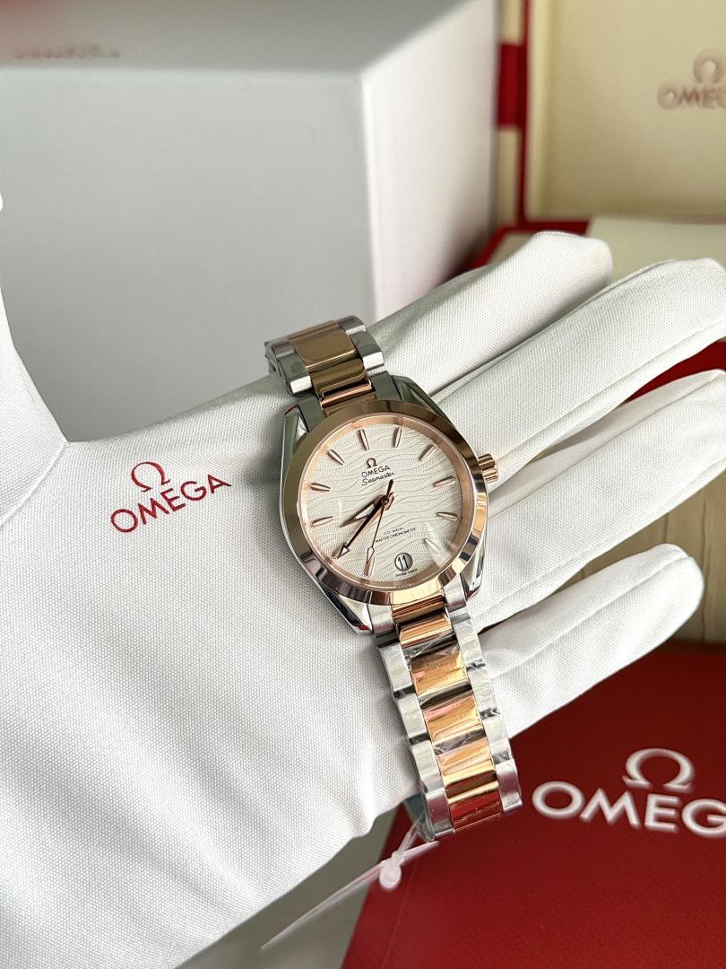 Omega wristwatch with two-tone metal bracelet and champagne dial on white glove