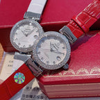 Omega watch pair with rhinestone bezels, white dials, red and gray straps
