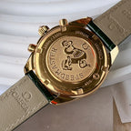 Gold-tone watch case back with textured detailing and crown posts