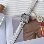 Round watch with white leather strap, crystal-set bezel, and three subdials