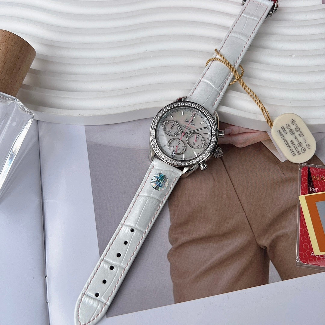 Round watch with white leather strap, crystal-set bezel, and three subdials