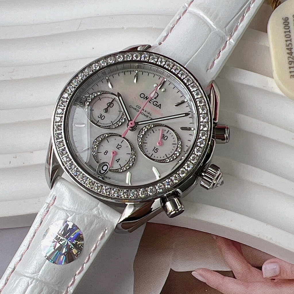 Round diamond-bezel watch with white leather strap and three subdials on a silver face