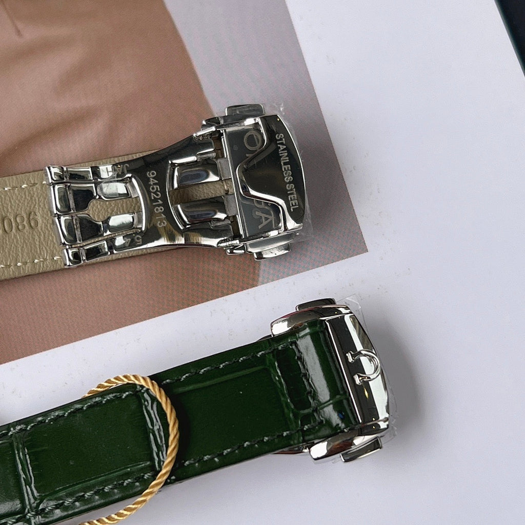 Silver watch case with metallic bracelet and engraved clasp, plus green leather strap