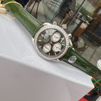 Omega watch with green leather strap, diamond bezel, black chronograph face on display