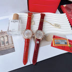 Two red leather strap wristwatches with round white dials and gold-toned cases
