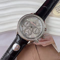 Omega chronograph watch with black leather strap, jeweled silver bezel, silver dial.