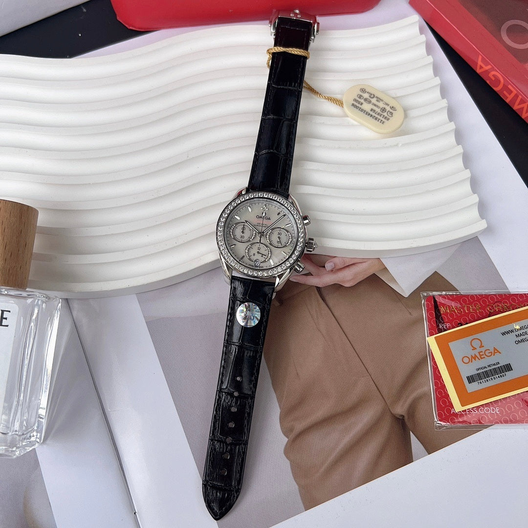 Omega chronograph watch with black leather strap and silver dial, held in hand.