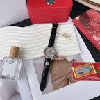 Omega chronograph watch with black leather strap and silver dial, held in hand.