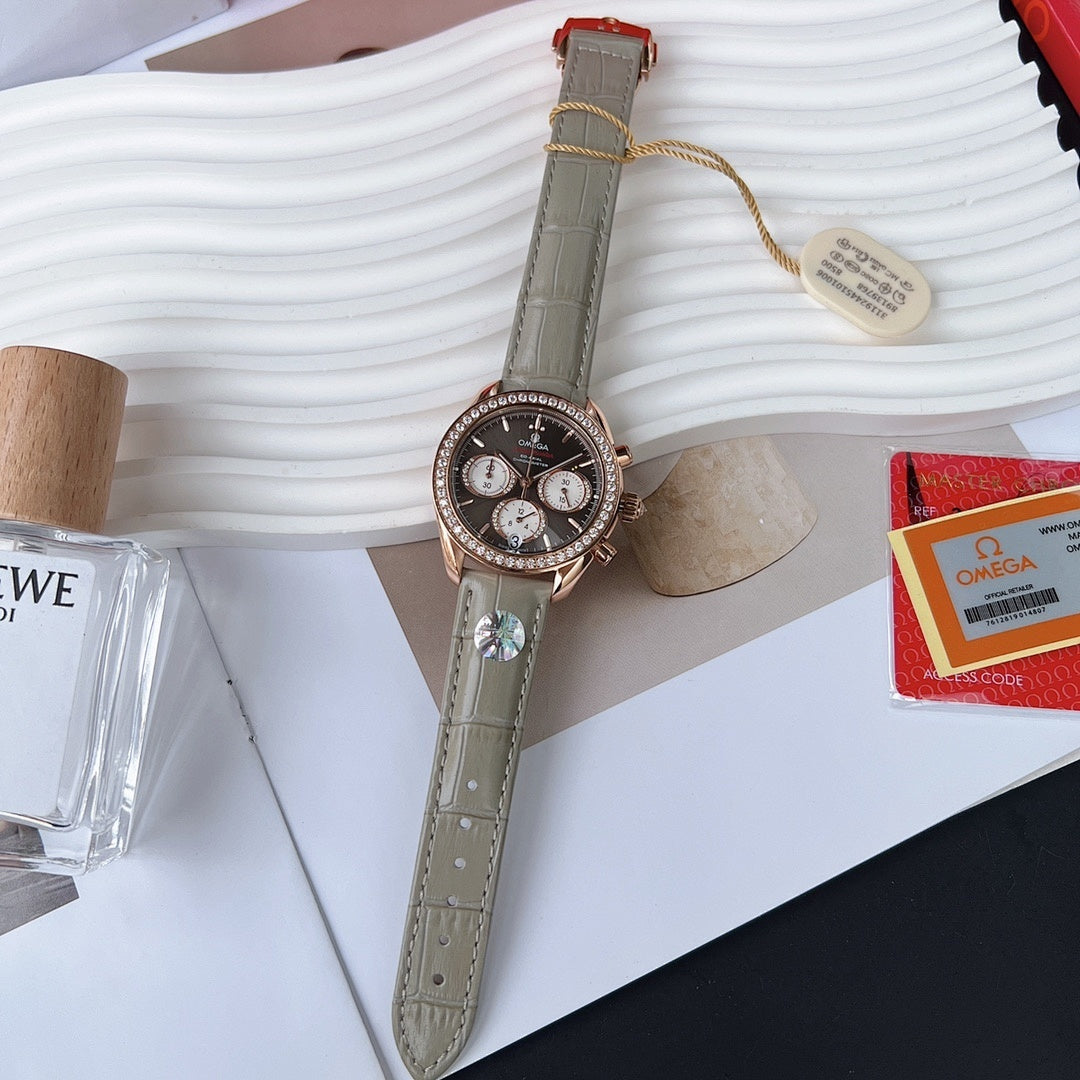 Omega chronograph wristwatch with dark dial, rose gold case and sparkling diamond bezel, gray strap