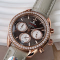 Omega chronograph wristwatch with dark dial, rose gold case, diamond bezel, gray leather strap