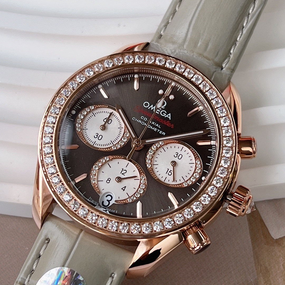 Omega chronograph wristwatch with dark dial, rose gold case, diamond bezel, gray leather strap