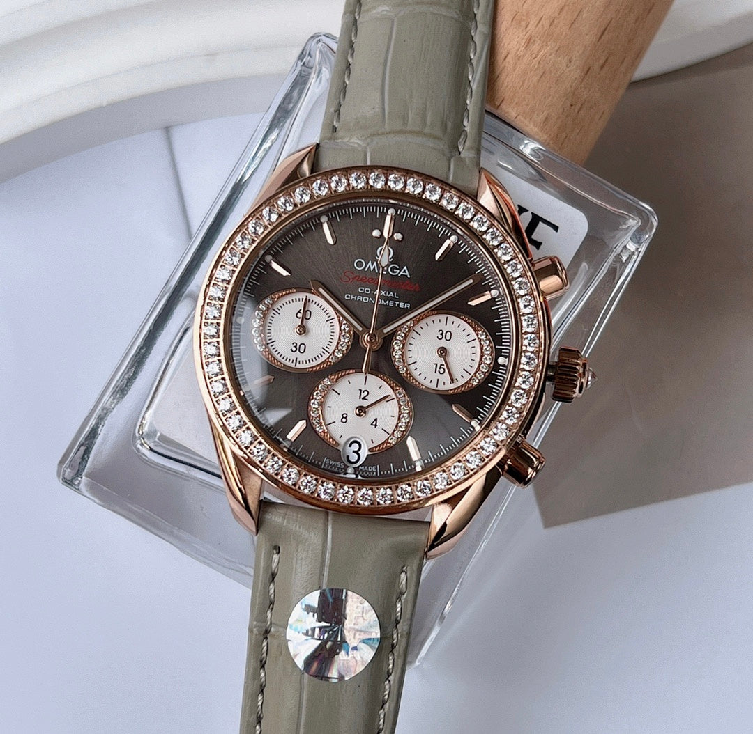 Omega chronograph wristwatch with dark dial, rose gold case, diamond-studded bezel, gray leather strap