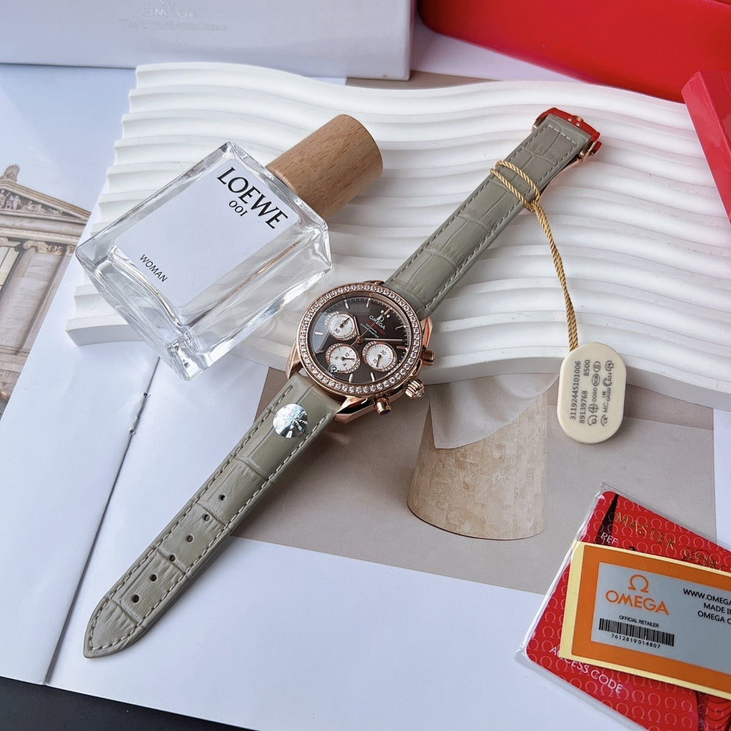 Omega chronograph wristwatch with dark dial, rose gold bezel stones, gray leather strap