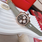Omega chronograph wristwatch, dark dial with subdials, rose gold bezel stones, gray leather strap