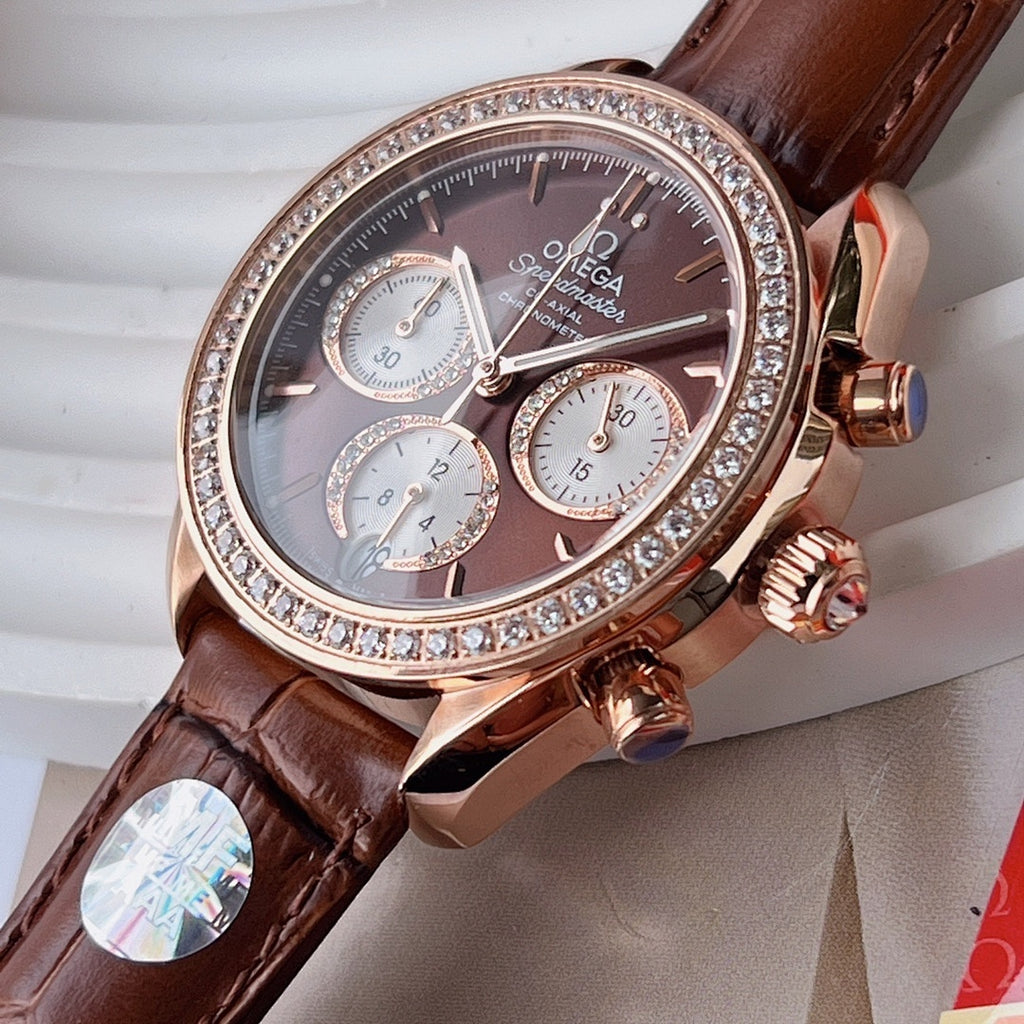 Omega watch close-up with brown leather strap, jeweled bezel, dark chronograph dial, rose case.