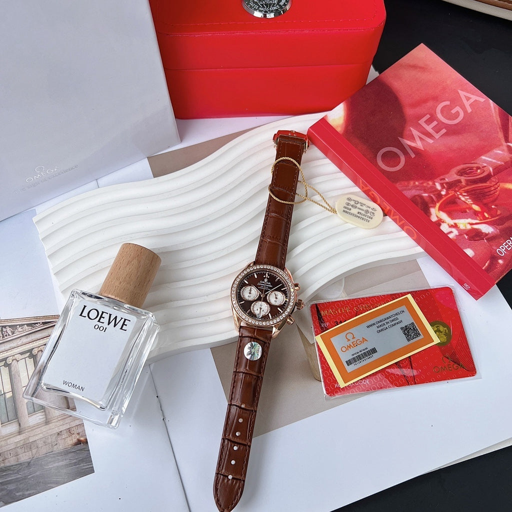 Omega watch with brown leather strap, jeweled bezel, dark chronograph dial on display stand.