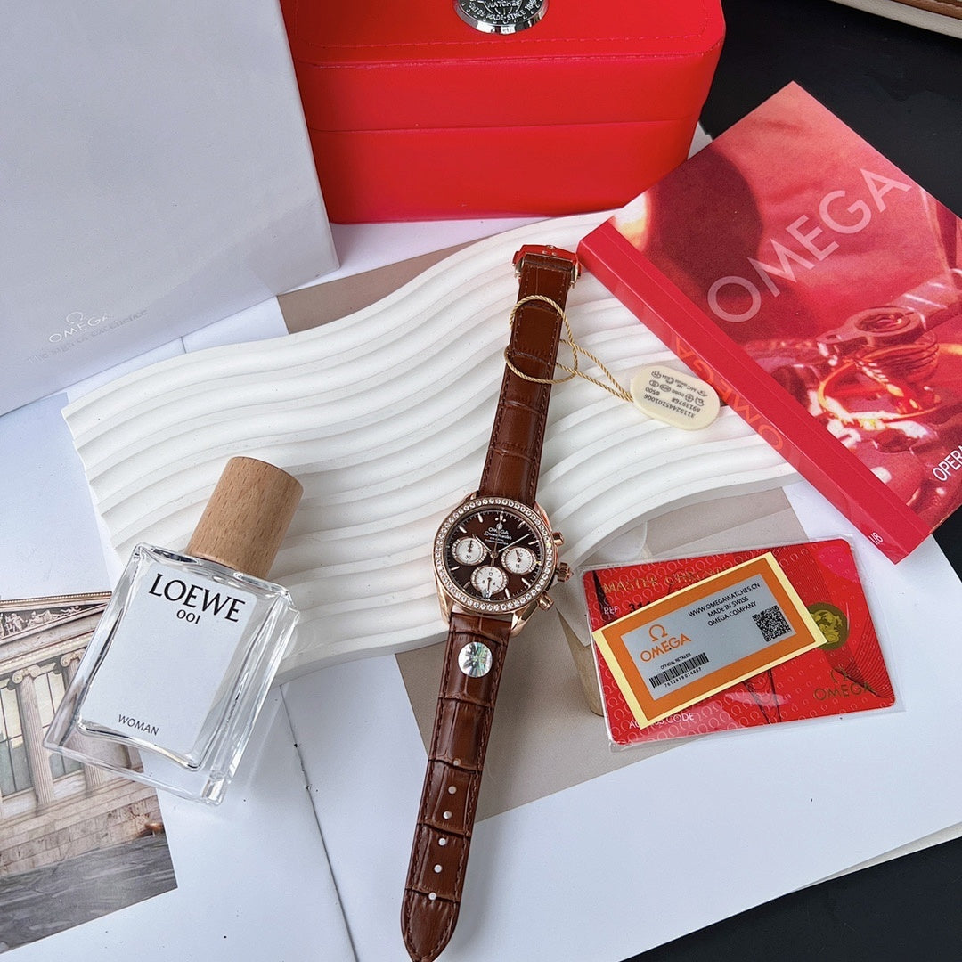Omega watch with brown leather strap, jeweled bezel, dark chronograph dial on display stand.