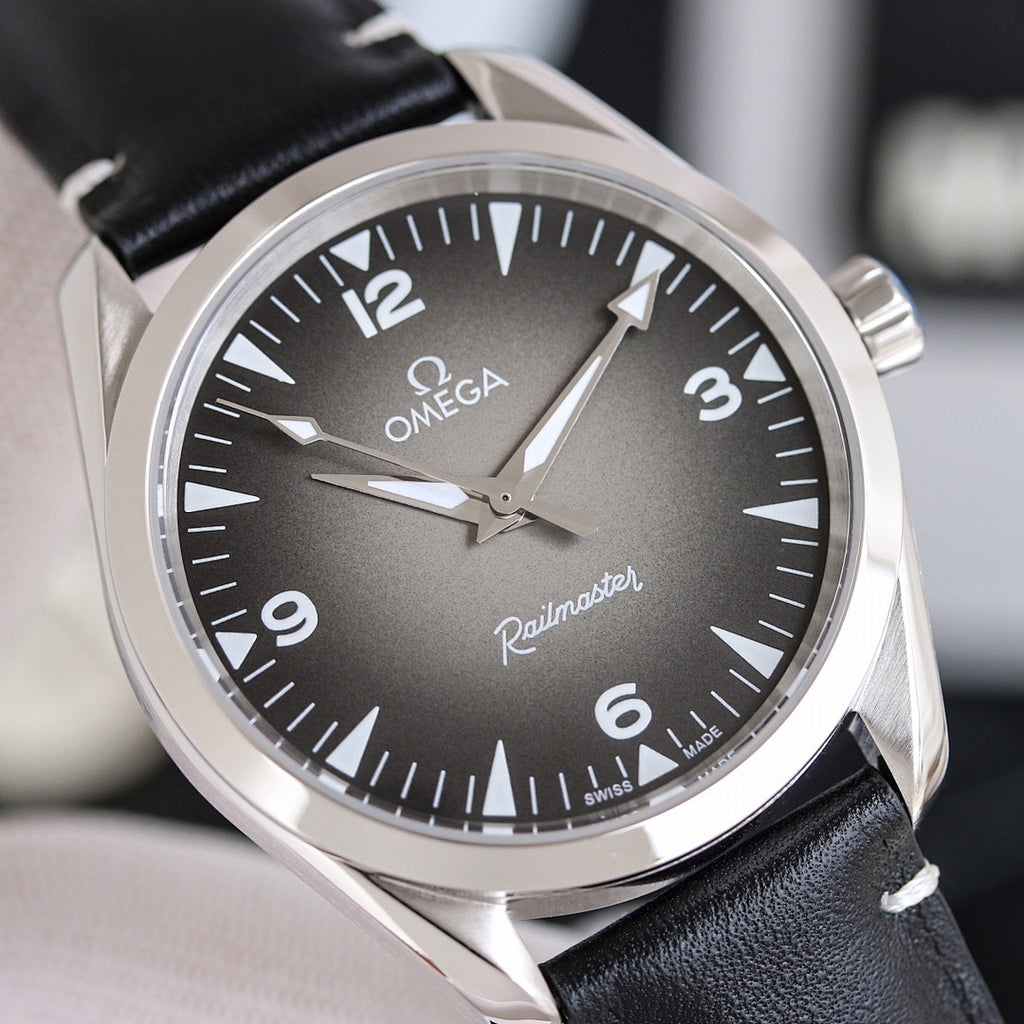 Omega watch dial close-up with dark dial, black leather strap and silver case.