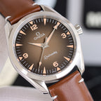 Omega watch with brown dial and brown leather strap, stainless case, angled view.