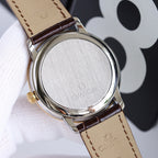 Omega watch caseback in brushed metal with brown leather strap