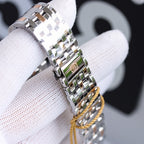 Metal link watch bracelet with clasp, worn on a glove