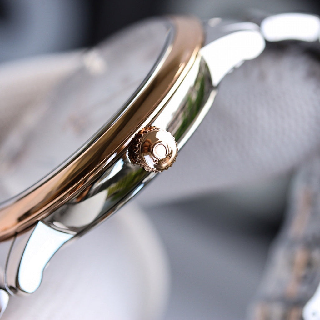Stainless steel watch case with crown, polished gold-tone side