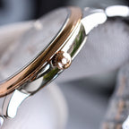 Stainless steel watch case with crown, polished gold-tone side