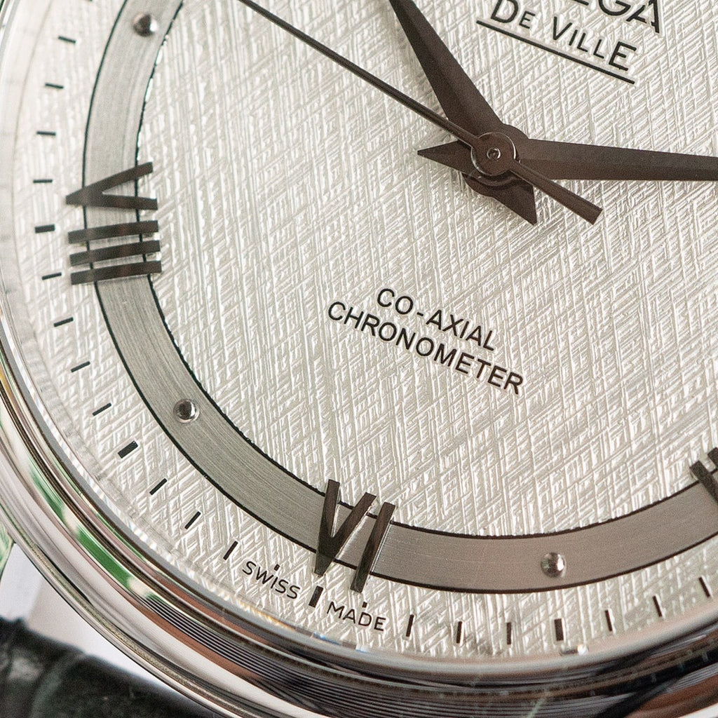 Omega De Ville watch dial close-up showing roman numerals and Co-Axial Chronometer text