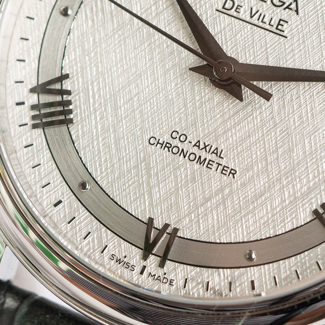 Omega De Ville watch dial close-up showing roman numerals and Co-Axial Chronometer text