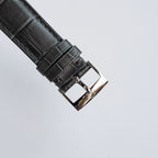 Black leather watch strap with metal buckle and clasp