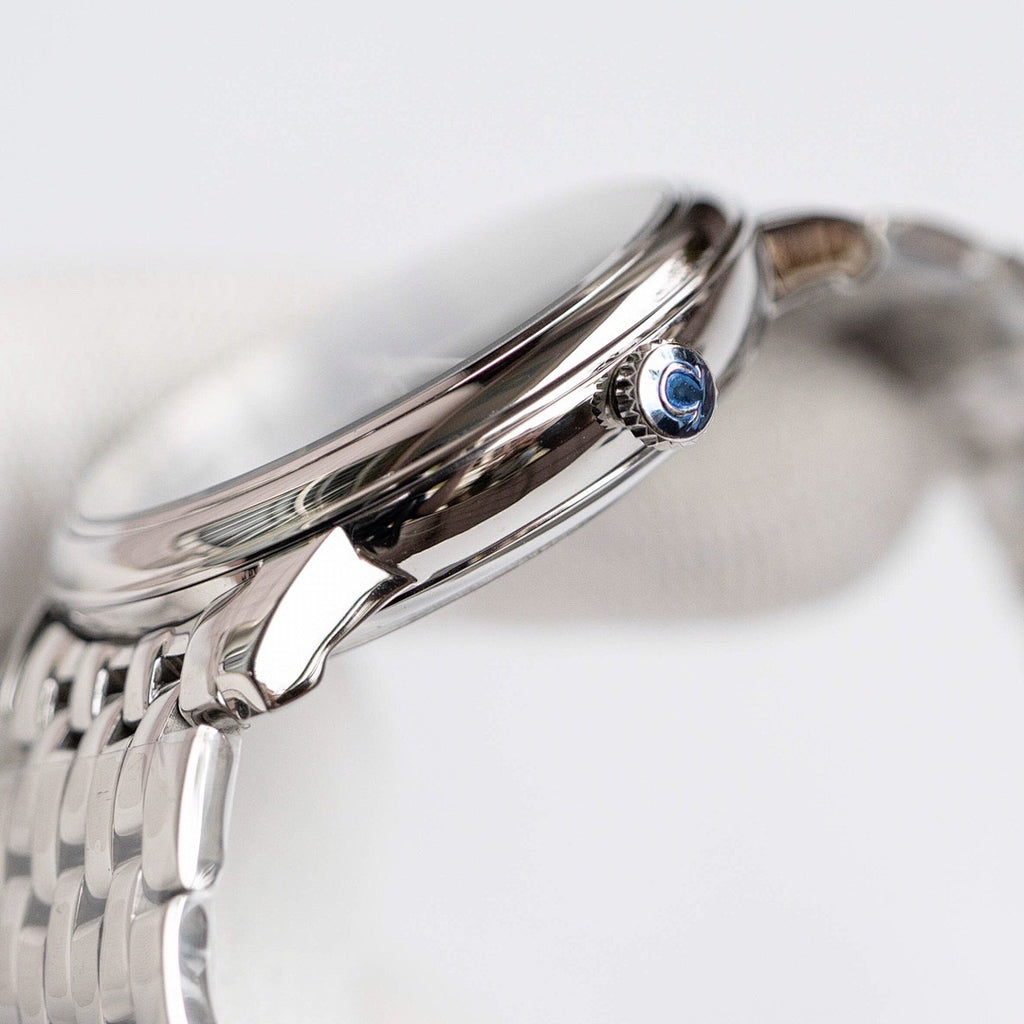Omega wristwatch with polished stainless steel case, crown, and blue gem detail