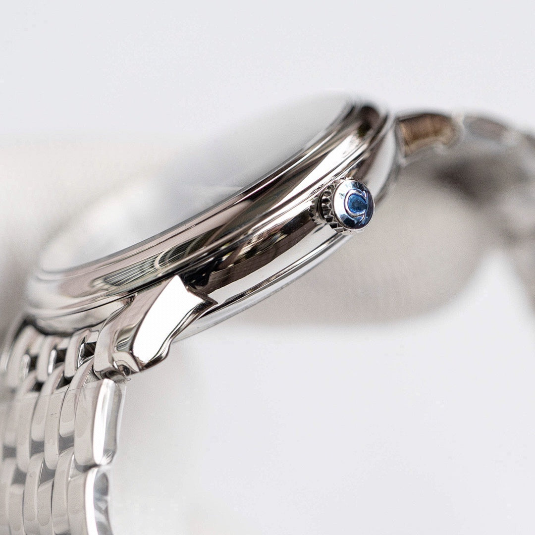 Omega wristwatch with polished stainless steel case, crown, and blue gem detail