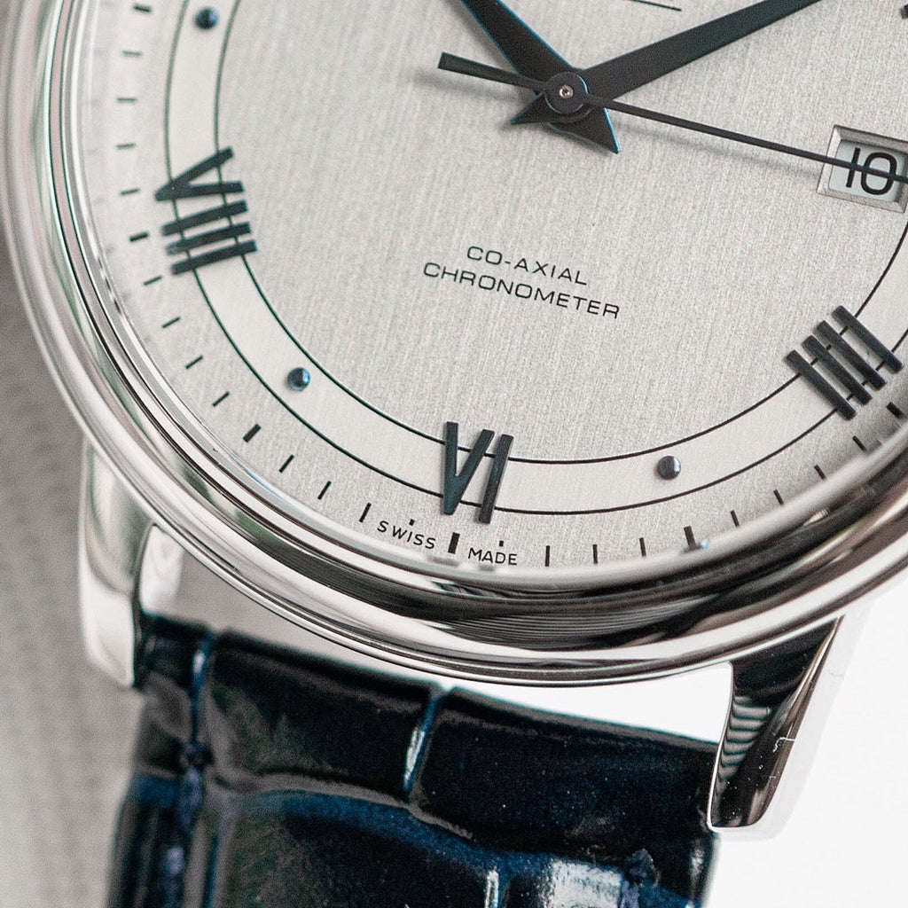 Omega De Ville watch dial close-up with Roman numerals and Co-Axial Chronometer text