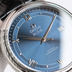 Omega De Ville wristwatch close-up with blue dial, Roman numerals, silver hands and 12 marker