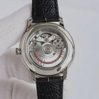 Omega watch case back showing mechanical movement and black leather strap