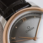 Analog wristwatch dial close-up with gold hands, Roman numerals, leather strap
