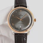 Analog wristwatch, dark gray dial, gold-tone case, black leather strap, day-date window