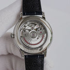 Omega watch case back with visible mechanical movement and black leather strap.