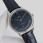 Omega wristwatch: dark blue dial, silver case, black leather strap.