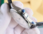 Omega wristwatch angled side view with blue crown detail and black leather strap.